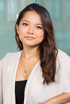 A woman wearing a white blazer and black top.